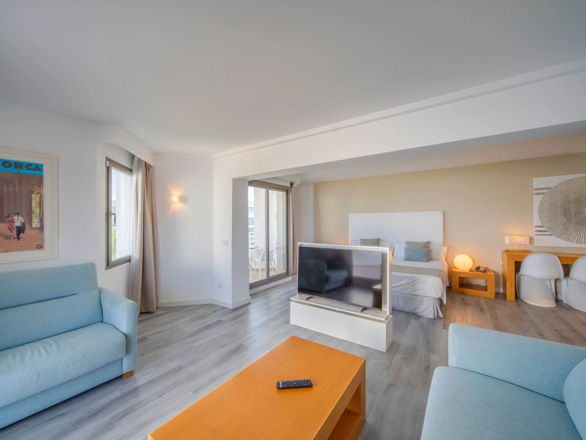 Suite de hotel con sala de estar, cama grande y vista a la terraza. Playa Esperanza Resort