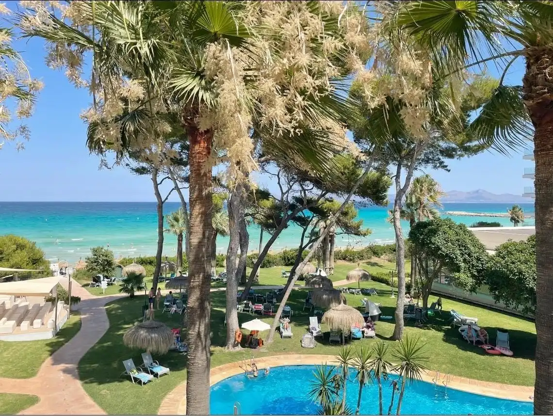 Playa Esperanza Resort: Piscina azul y playa tropical con palmeras y césped verde.