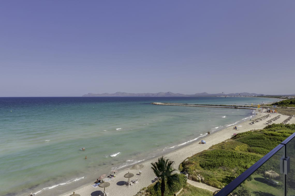 Vista aérea de playa con tumbonas y mar turquesa, ideal para Playa Esperanza Resort.