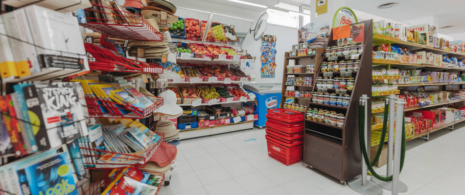 Estanterías de tienda con libros, frutas, sombreros y productos, ideal paraPlaya Esperanza Resort.