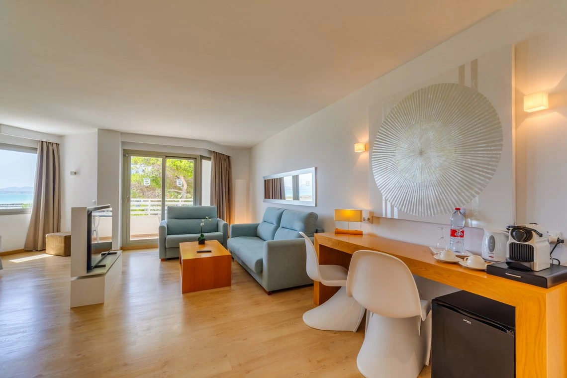 Playa Esperanza Resort: sala de estar luminosa con sofás, mesa de centro, escritorio y vista al mar.