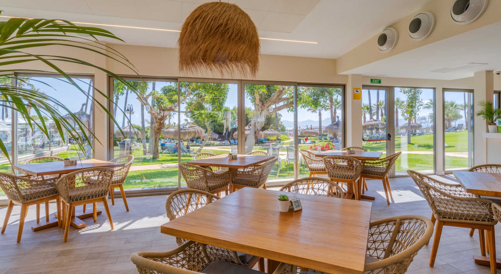 Comedor interior con vistas a la playa y jardines, ideal para Playa Esperanza Resort.