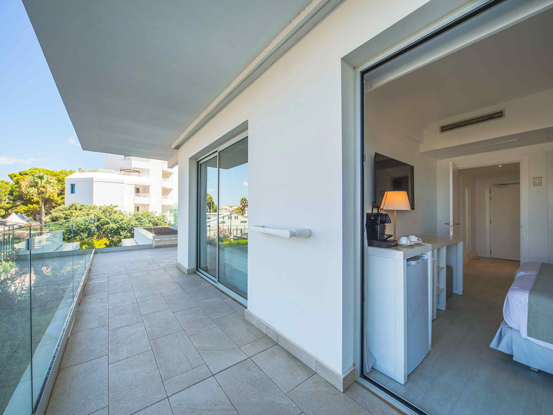 Balcón moderno con vista exterior yPlaya Esperanza Resort en habitación de hotel.