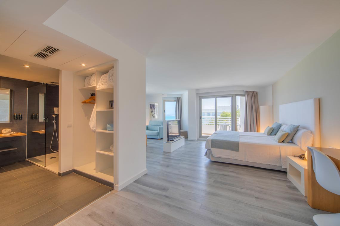 Suite luminosa con cama doble, baño moderno y balcón con vistas al mar. Playa Esperanza Resort