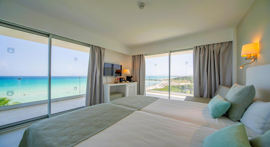 Habitación de hotel con vista al mar: camas, balcón y Playa Esperanza Resort.