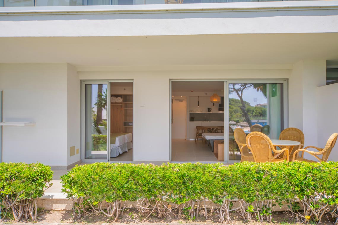 Terraza privada con Playa Esperanza Resort, muebles de exterior y vista a la habitación.