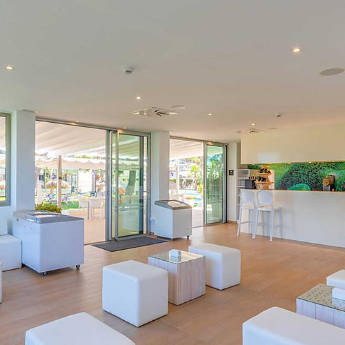 Lounge interior con barra, sofás y mesas, ideal para Playa Esperanza Resort.