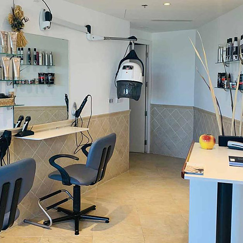 Salón de belleza con sillas, espejos y productos de peluquería en Playa Esperanza Resort.