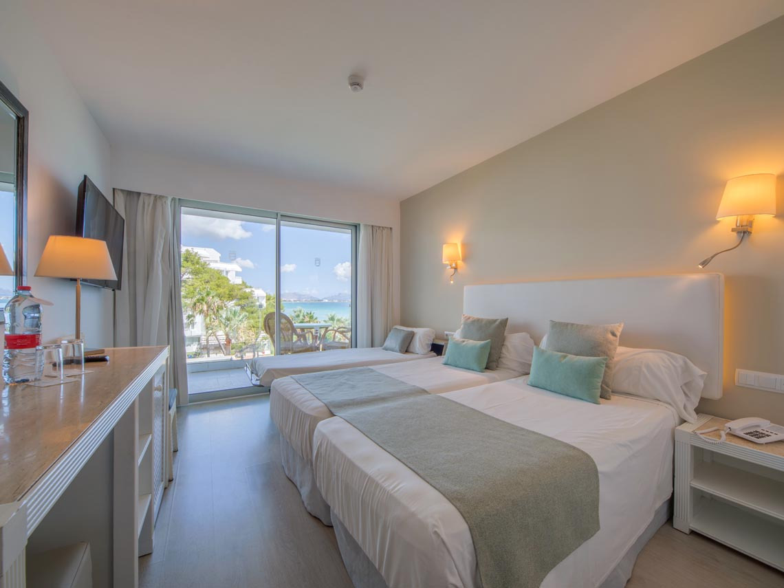 Habitación doble con dos camas, vista al mar y balcón, ideal para Playa Esperanza Resort.