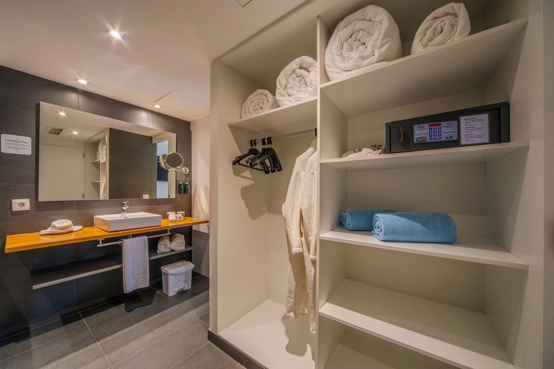 Armario de hotel con toallas, caja fuerte y batas, perfecto para tu Playa Esperanza Resort.