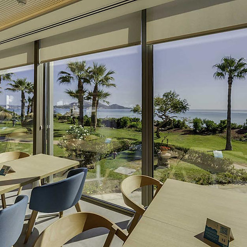 Terraza de restaurante con vista al mar Playa Esperanza Resort. Mesas y sillas modernas.