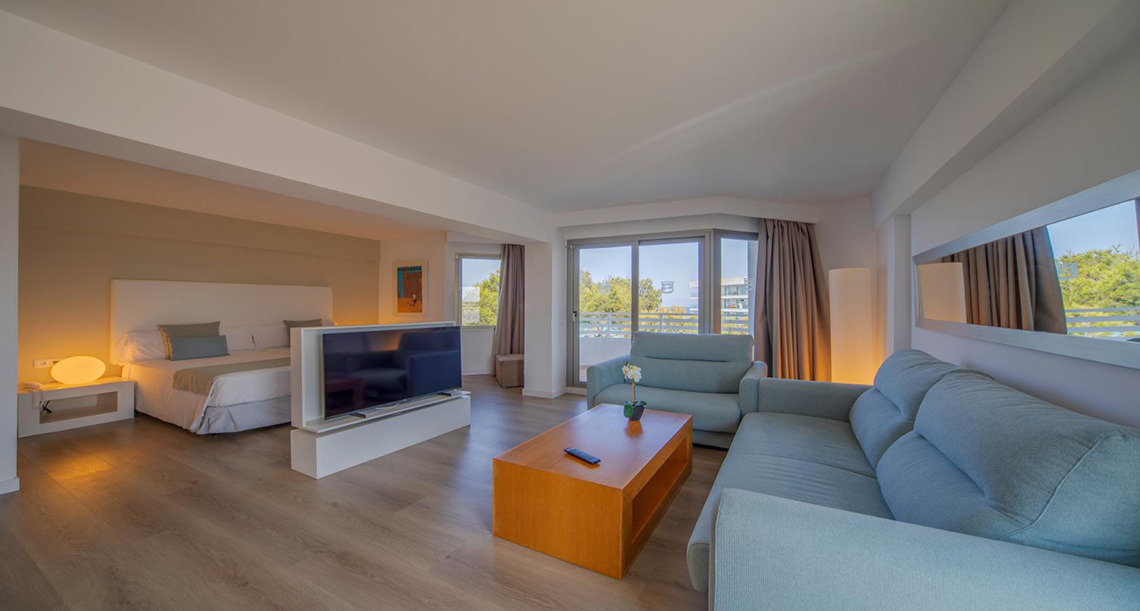 Amplia suite con cama, sala y balcón. Playa Esperanza Resort moderno y espacioso.