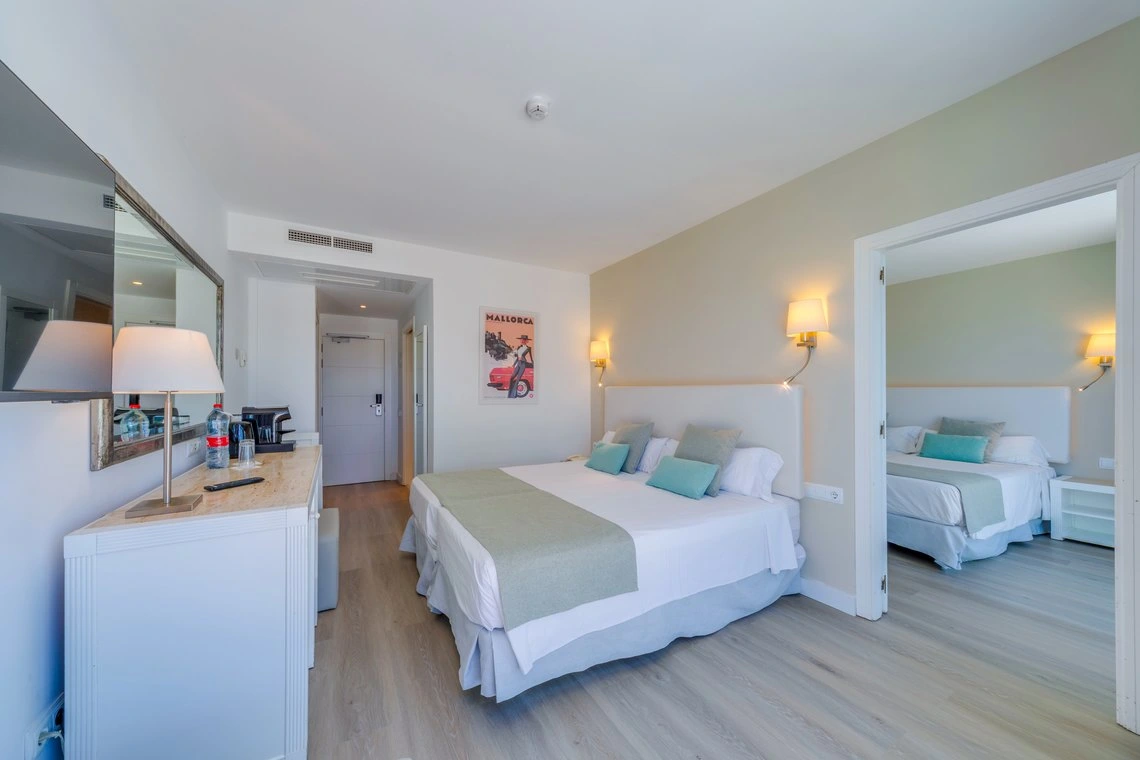 Habitación doble con camas gemelas, cómoda y espejo en Playa Esperanza Resort.