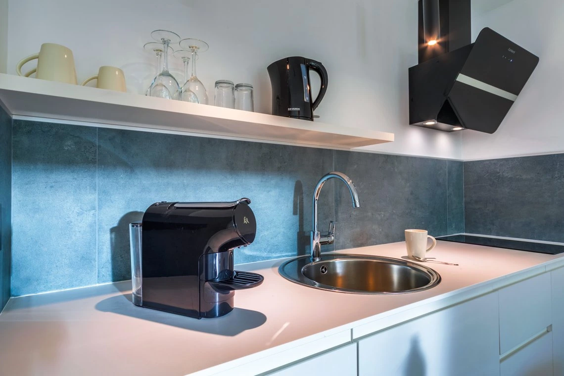 Cocina moderna en hotel con cafetera Playa Esperanza Resort, fregadero y electrodomésticos.