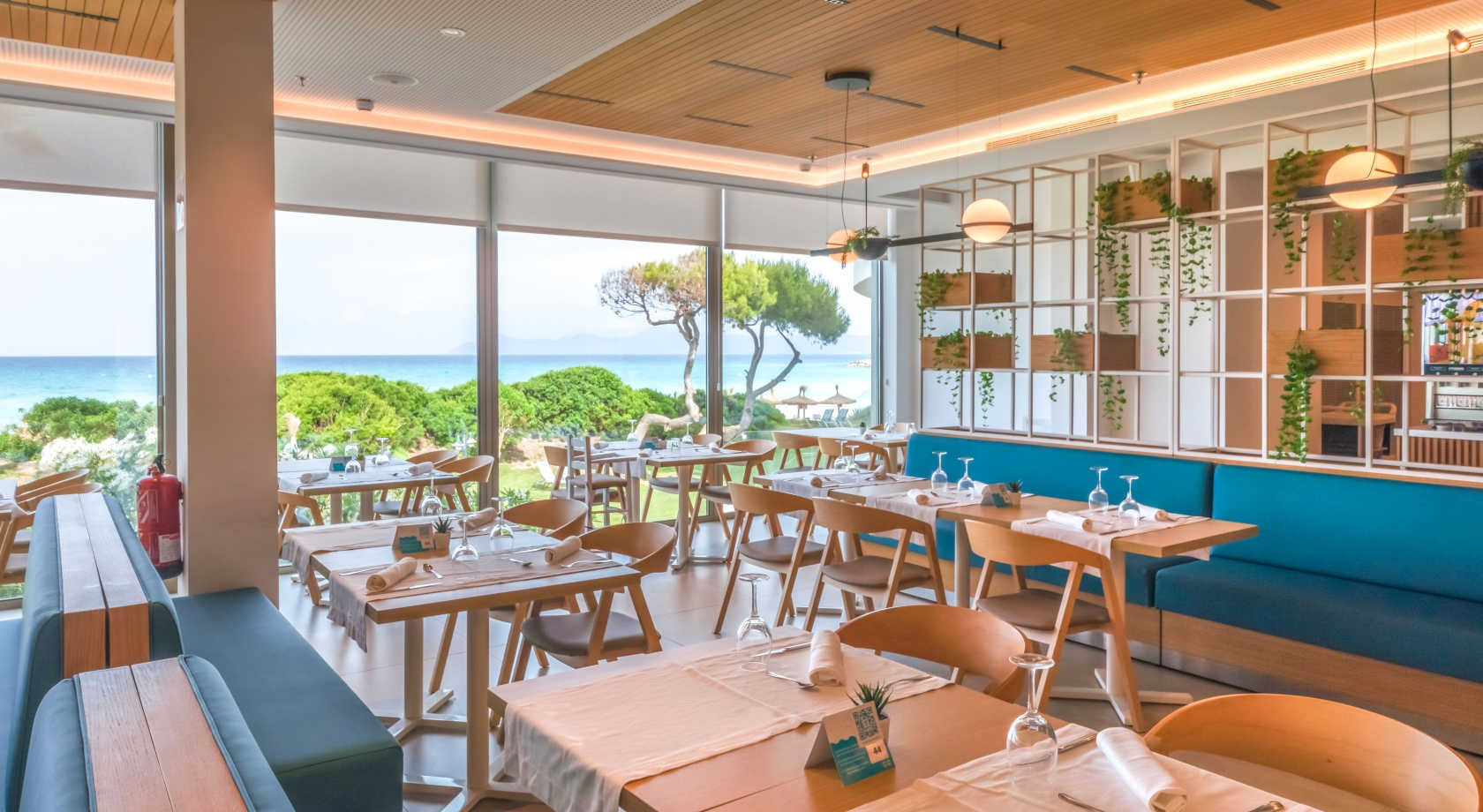 Restaurante con vista al mar, mesas decoradas y ambiente luminoso. Playa Esperanza Resort