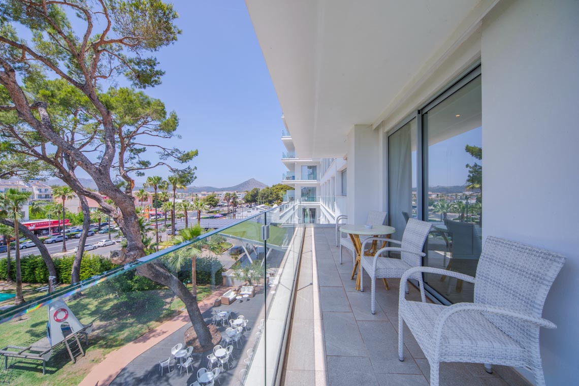 Balcón con sillas y mesa al aire libre y vistas a la ciudad y al mar. Playa Esperanza Resort