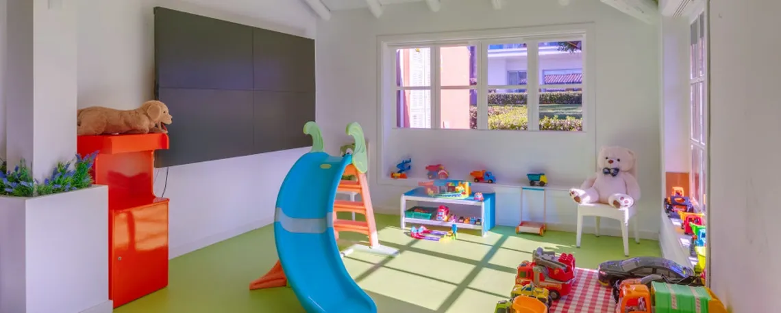 Sala de juegos infantil en hotel: tobogán, osos de peluche y juguetes Playa Esperanza Resort.