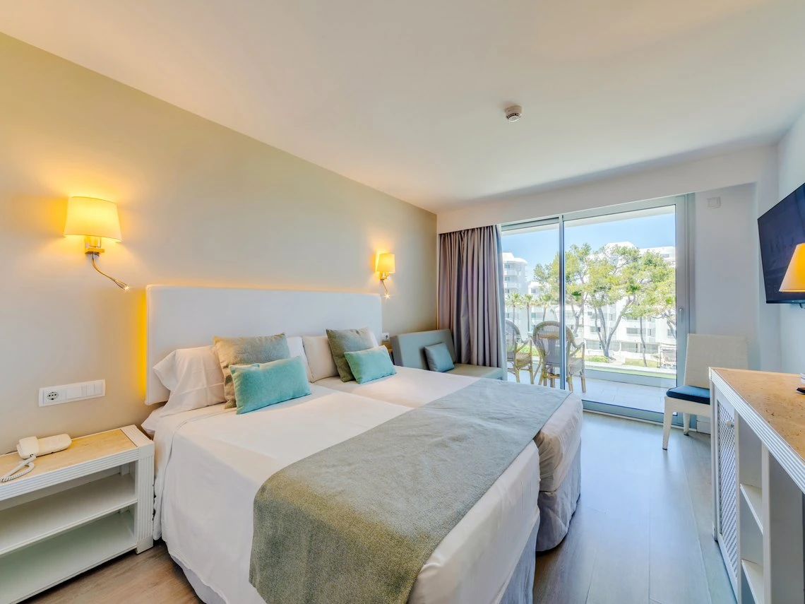 Habitación doble con balcón, ideal para Playa Esperanza Resort, con camas cómodas y vistas al exterior.