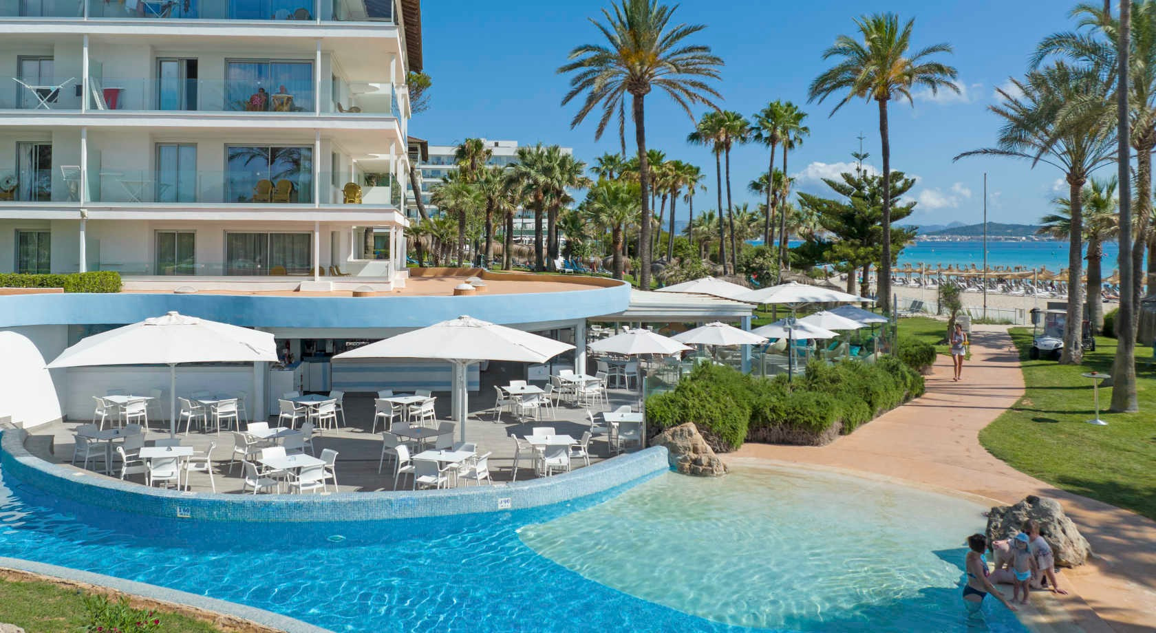 Playa Esperanza Resort: Terraza de hotel frente al mar con piscina y palmeras