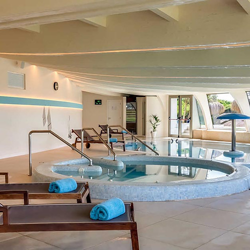 Piscina interior con tumbonas y arte mural enPlaya Esperanza Resort