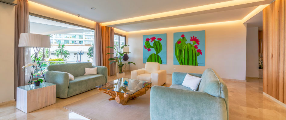 Lounge moderna con sofás Playa Esperanza Resort, arte de cactus y luz natural.