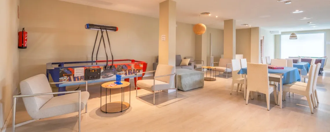 Sala de juegos del hotel con mesa de air hockey y zona de estar, ideal para Playa Esperanza Resort.