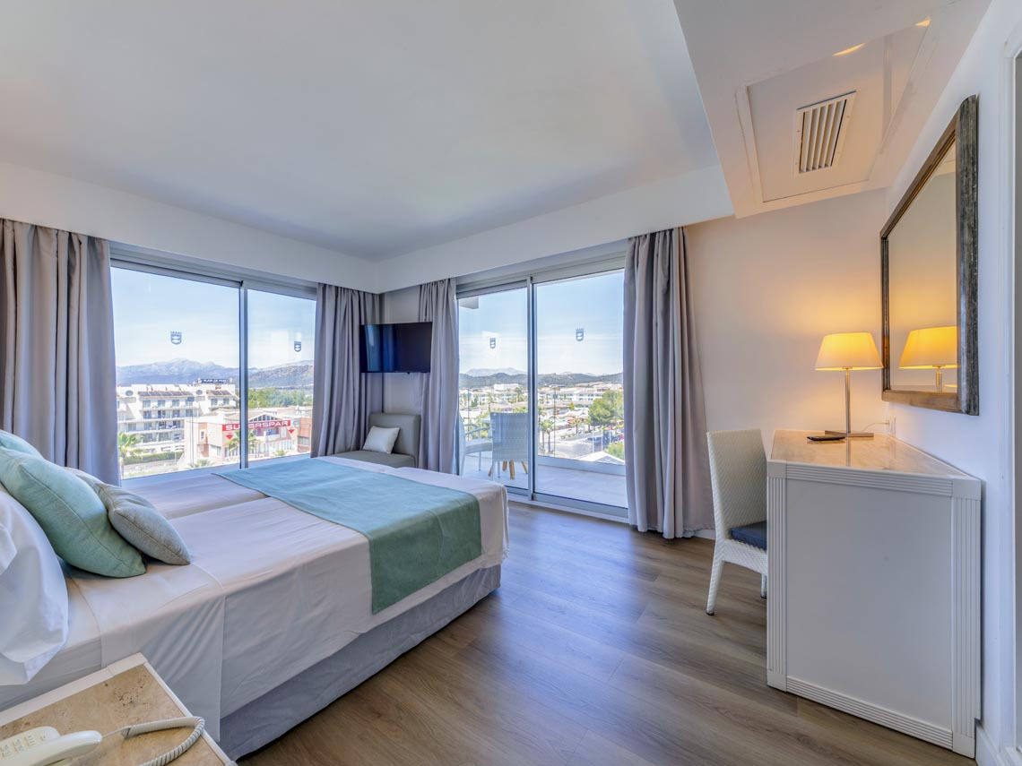 Habitación de hotel con cama doble, balcón y vistas al mar. Playa Esperanza Resort de lujo.