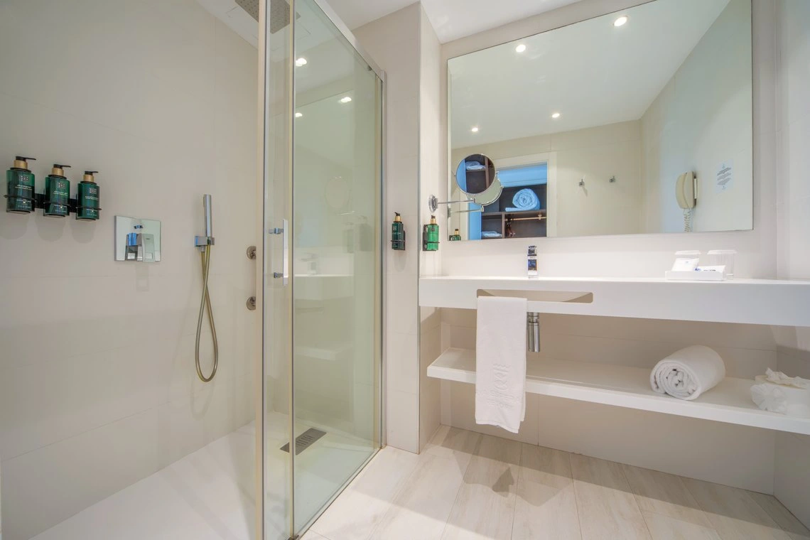 Modern baño con ducha de cristal y lavabo. Playa Esperanza Resort ideal para relax.