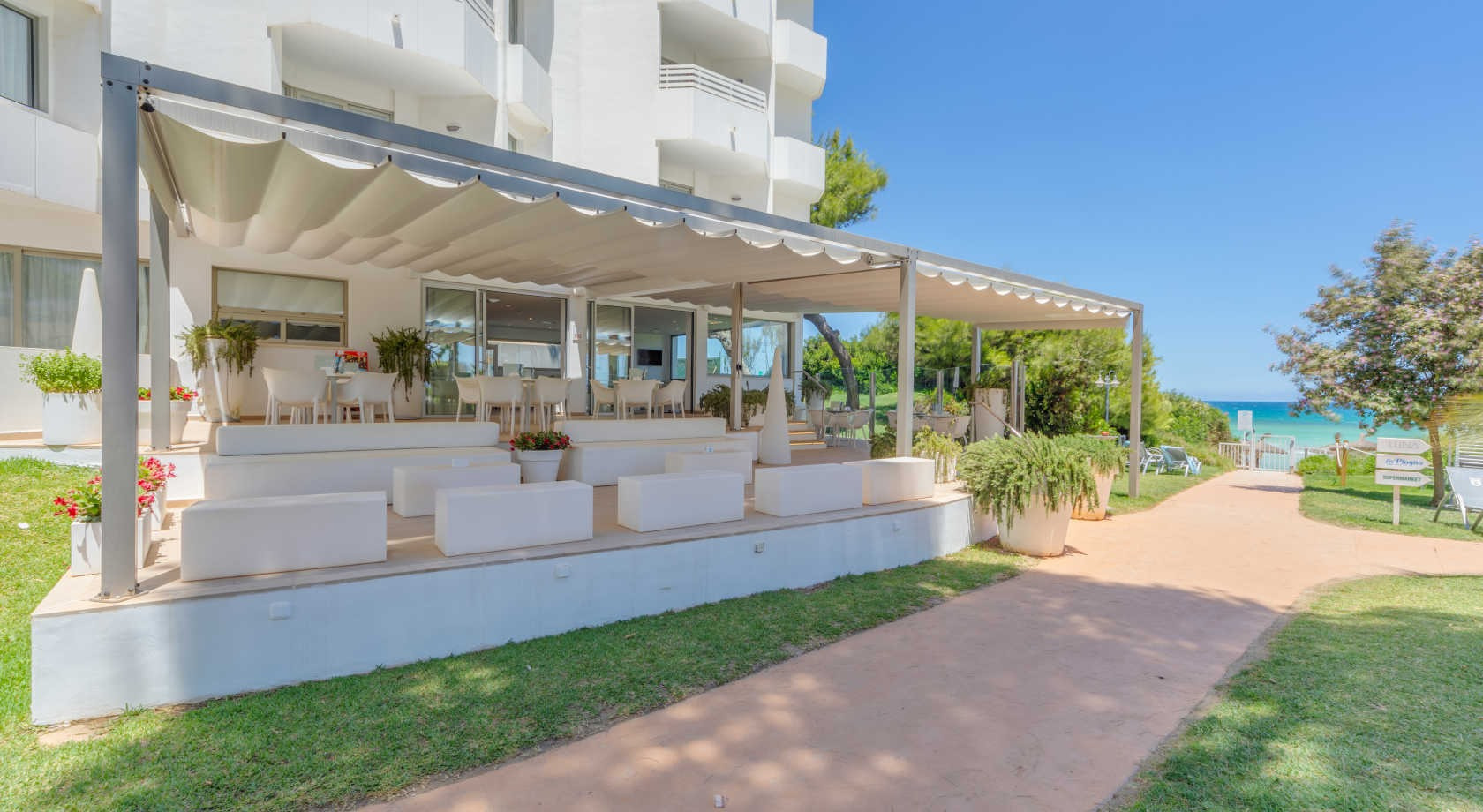 Terraza al aire libre de un hotel con asientos y vista al mar, ideal paraPlaya Esperanza Resort.
