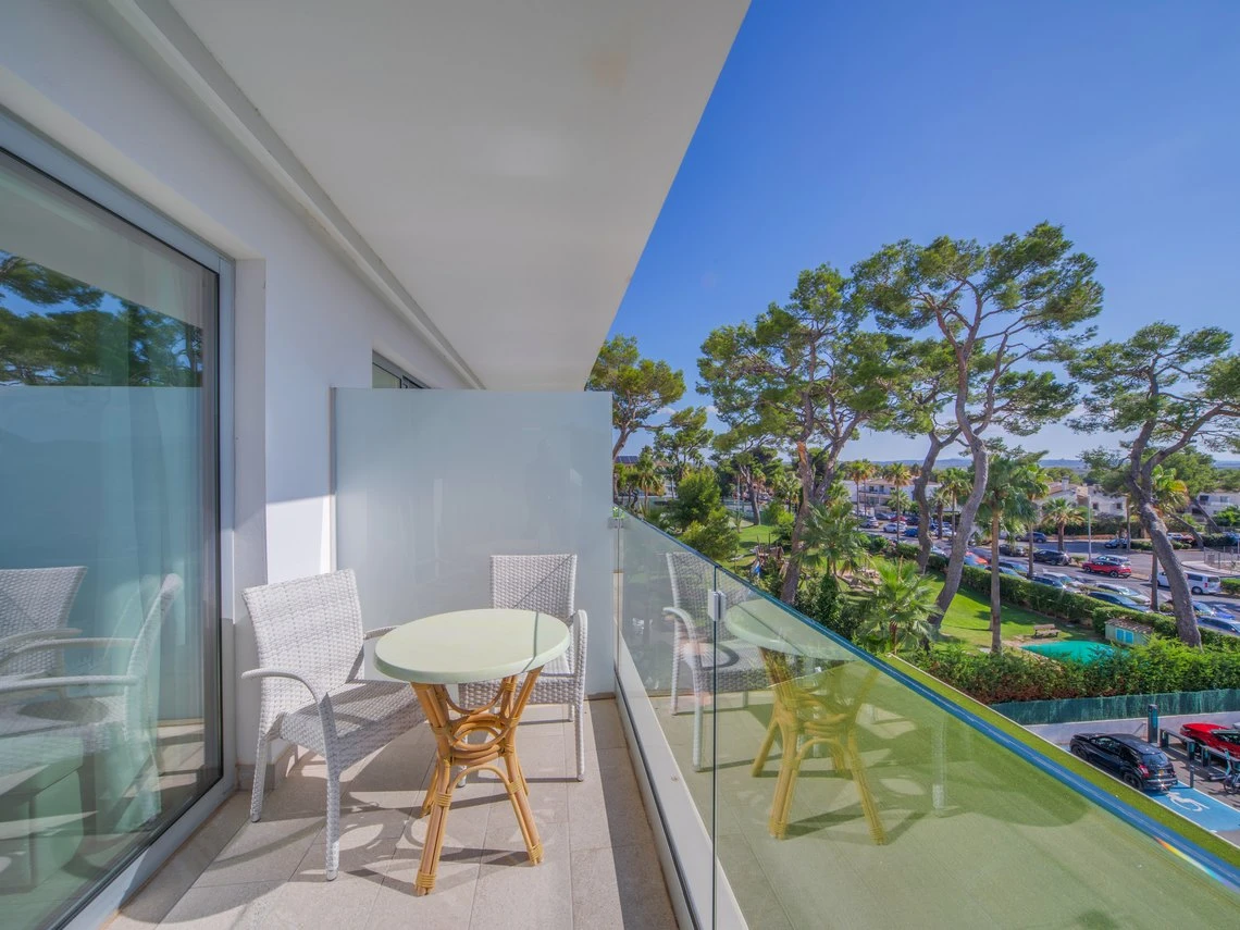 Balcón moderno con mesa y sillas, vista al parque y mar Playa Esperanza Resort