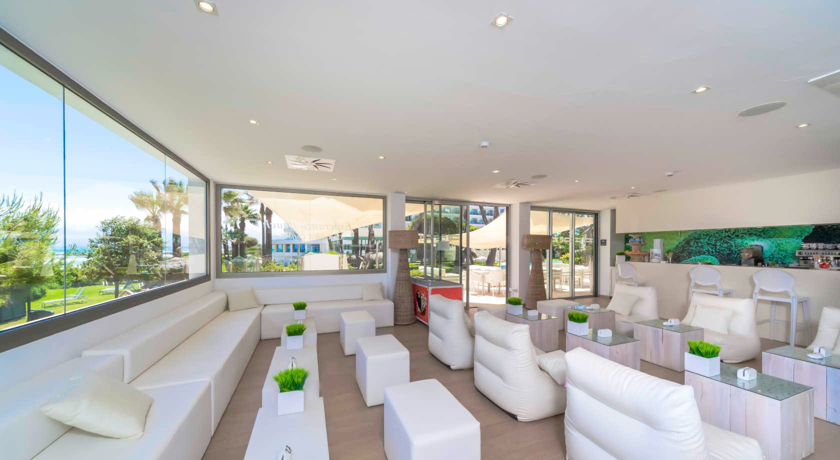Playa Esperanza Resort: sala lounge moderna con vistas al mar y sofás blancos.