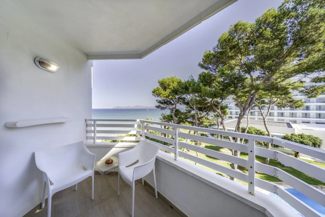 Balcón con sillas blancas y vista al mar, perfecto para tu Playa Esperanza Resort.