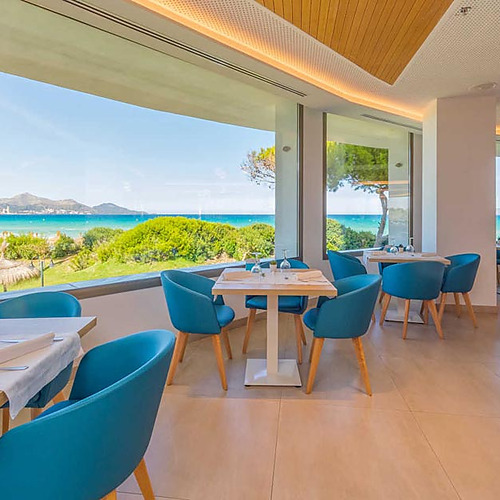 Comedor elegante con vistas al mar y palmeras, ideal para Playa Esperanza Resort.