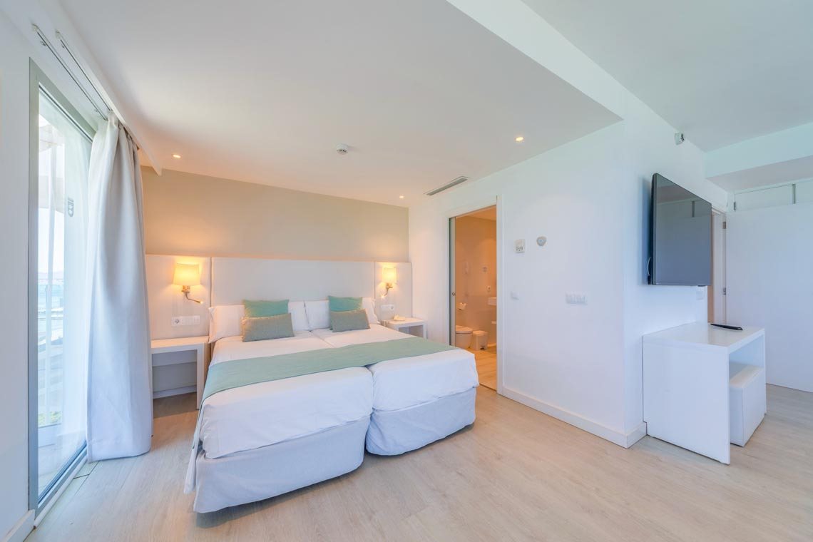 Habitación de hotel con cama doble y baño accesible. Playa Esperanza Resort