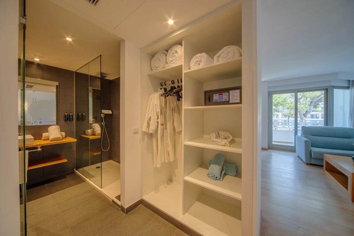 Baño moderno con ducha, armario con batas y caja fuerte en hotel Playa Esperanza Resort.