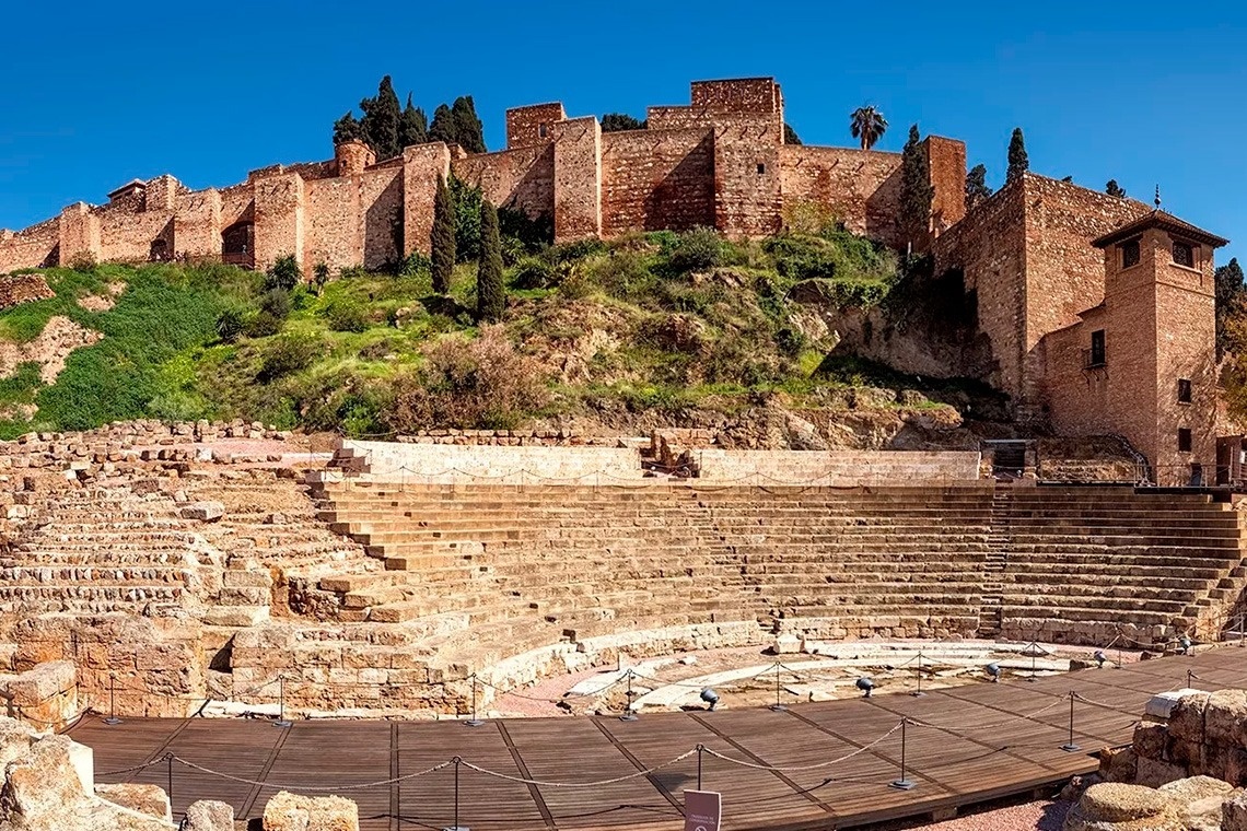 un anfiteatro antiguo con un castillo en el fondo