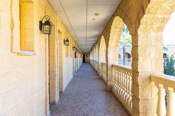 un pasillo largo con columnas de ladrillo y balcones