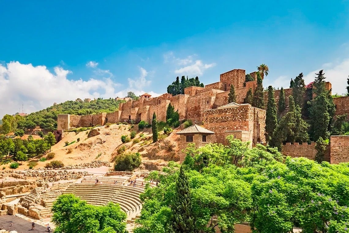 a castle sits on top of a hill surrounded by trees