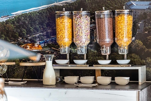 a buffet table with bowls of cereal and a pitcher of milk