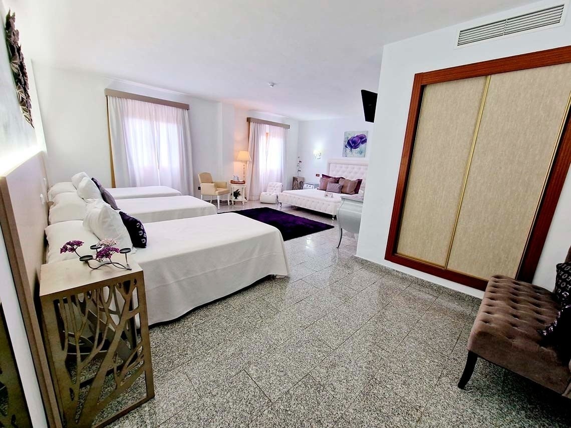 a hotel room with three beds and a purple rug