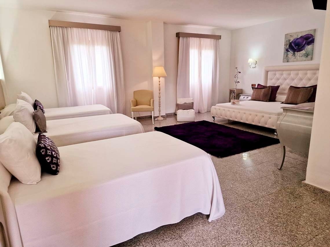 una habitación con tres camas y una alfombra morada