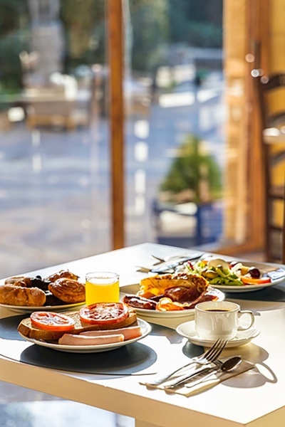 a table with plates of food and a glass of orange juice