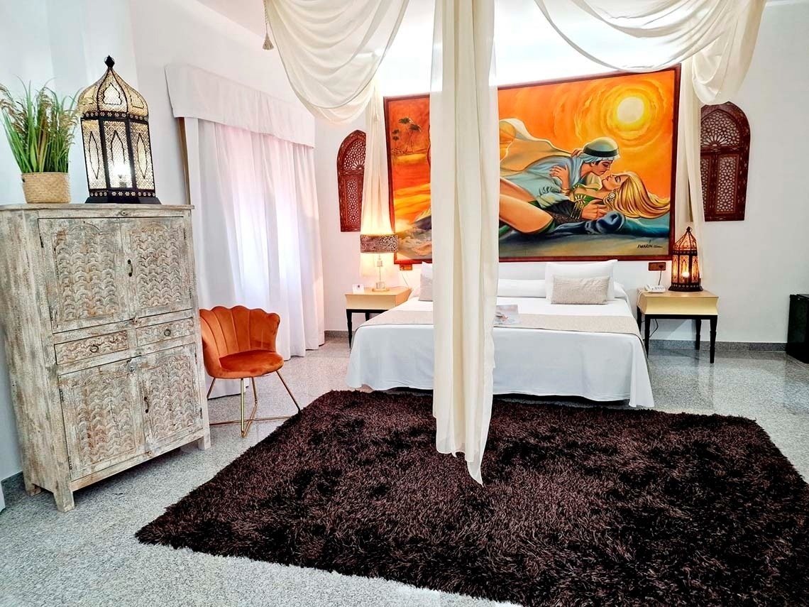 a bedroom with a canopy bed and a painting on the wall