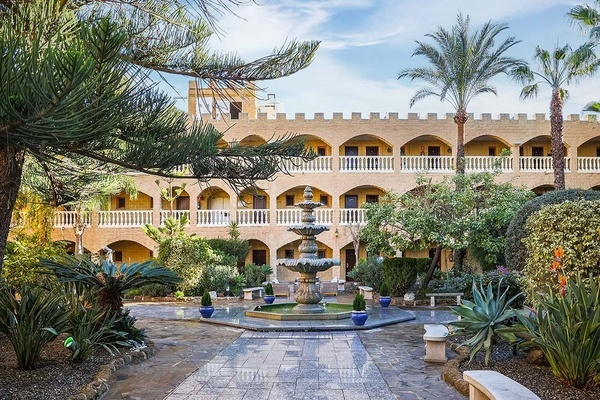 una fuente en el medio de un patio frente a un castillo