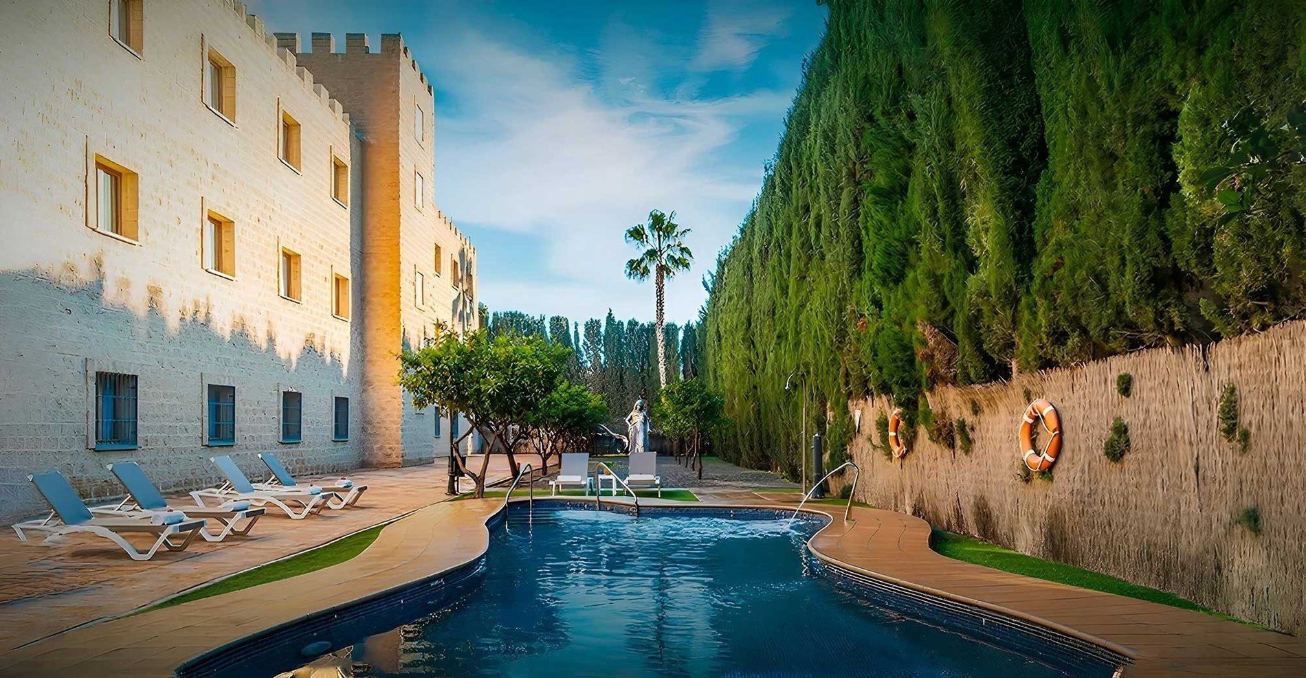 a swimming pool surrounded by chairs and a building