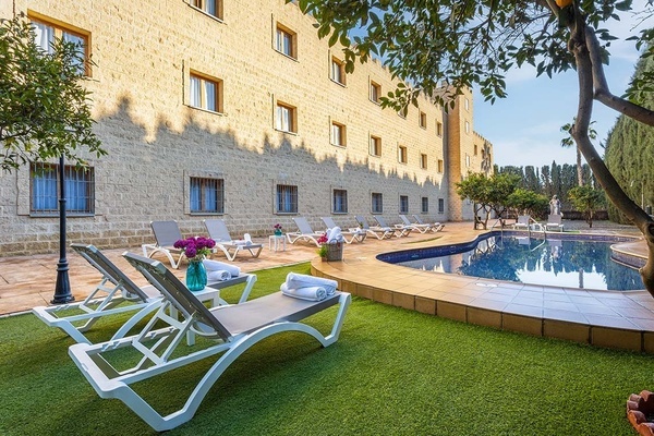 a swimming pool surrounded by chairs and a building