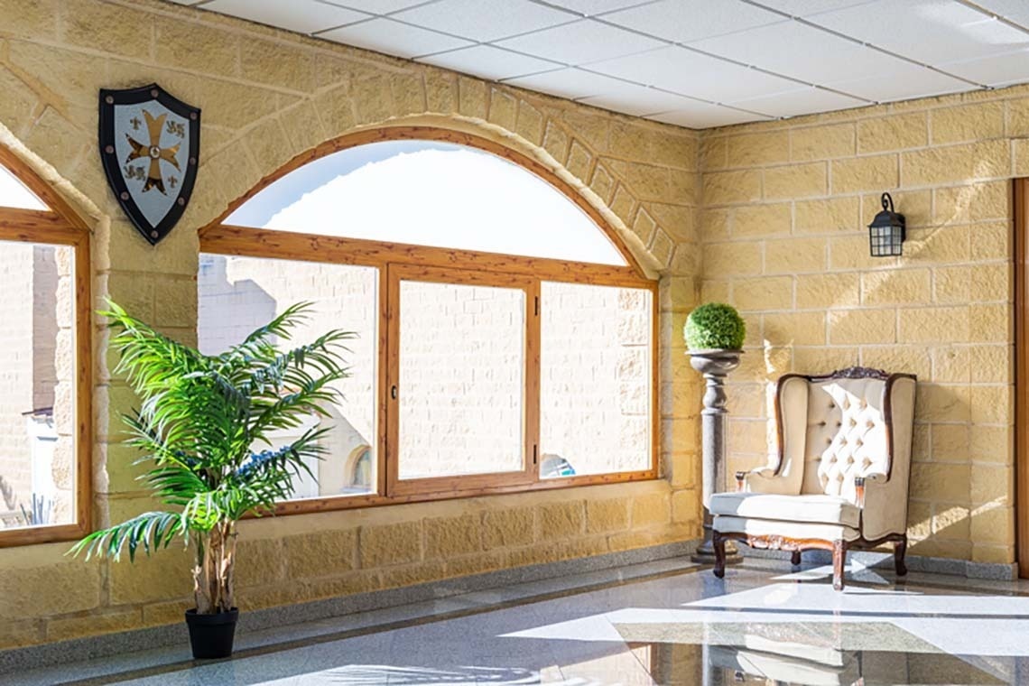 una habitación con una silla y un escudo en la pared