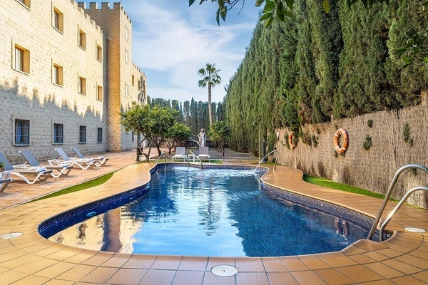 una piscina rodeada de árboles y sillas de playa