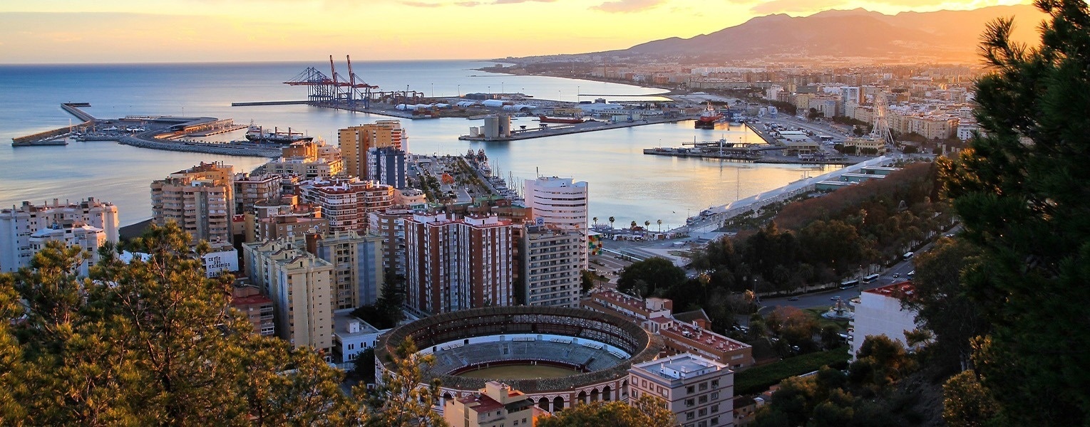 un anfiteatro rodeado de edificios y un puerto al atardecer