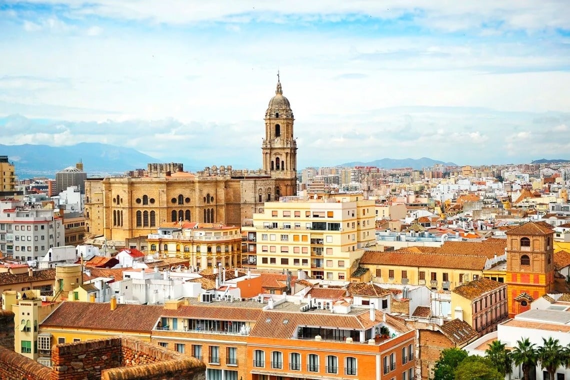 una vista aérea de una ciudad con una torre de la catedral en el fondo